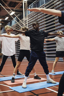 Jungen und Mädchen mit ausgestreckten Armen trainieren auf dem Basketballplatz - MASF34345