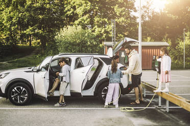 Familie lädt Elektroauto an Station - MASF34393