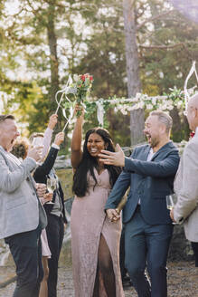 Glückliches frisch verheiratetes Paar genießt mit Familie und Freunden bei der Hochzeit - MASF34448