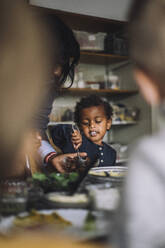 Eine Lehrerin serviert einem Jungen beim Frühstück im Kindergarten das Essen - MASF34576