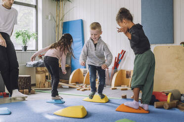 Happy male and female students playing in kindergarten - MASF34611