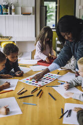 Lehrerin, die Schülern im Kindergarten das Erkennen von Farben beibringt - MASF34618