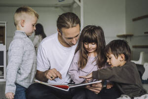 Lehrerin liest mit Schülern in der Kindertagesstätte ein Märchenbuch - MASF34627