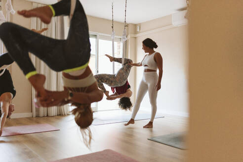 Yogalehrer unterrichtet Schüler im Studio in der Luft - OCAF00797