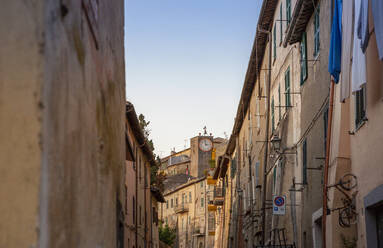 Italien, Latium, Capodimonte, Häuserzeilen mit öffentlicher Uhr im Hintergrund - MAMF02473