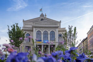 Deutschland, Bayern, München, Fassade des Gärtnerplatztheaters mit Blumenbeet im Vordergrund - MAMF02482