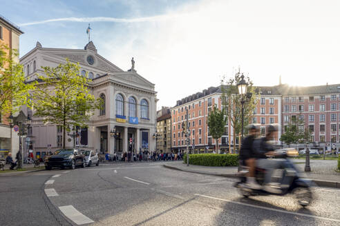 Deutschland, Bayern, München, Unscharfe Bewegung eines Motorrollers auf dem Gärtnerplatz bei Sonnenuntergang - MAMF02484