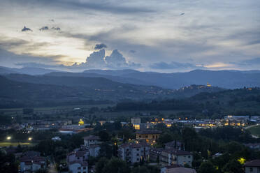 Italien, Toskana, Poppi, Blick auf eine ländliche Stadt im Casentino-Tal in der Abenddämmerung - MAMF02488