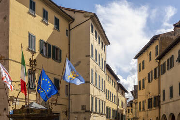 Italien, Toskana, Poppi, Nationalflaggen flattern an den Wohnhäusern der Altstadt - MAMF02498