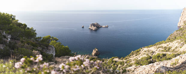 Spain, Balearic Islands, Panoramic view of Ses Margalides rock arch and surrounding sea seen from coastal clifftop - JAQF01211