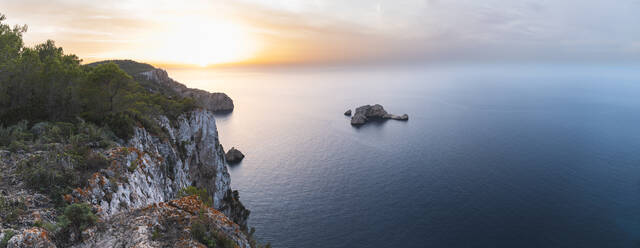 Spanien, Balearen, Panoramablick auf den Felsbogen von Ses Margalides und das umliegende Meer bei Sonnenuntergang von einer Klippe aus gesehen - JAQF01216