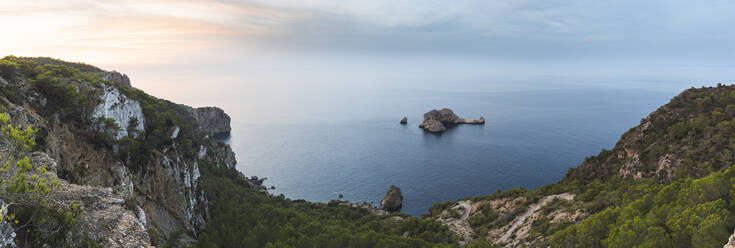 Spanien, Balearen, Panoramablick auf den Felsbogen von Ses Margalides und das umliegende Meer bei Sonnenuntergang von einer Klippe aus gesehen - JAQF01218