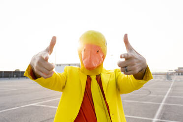 Man wearing duck mask gesturing in parking lot - OIPF02929
