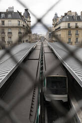 Frankreich, Ile-de-France, Paris, U-Bahnsteig durch Maschendrahtzaun gesehen - MMPF00632