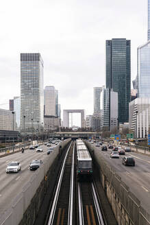 France, Ile-de-France, Paris, City traffic with skyscrapers of La Defense district in background - MMPF00646