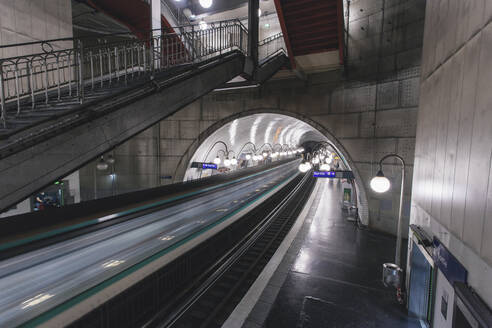 Frankreich, Ile-de-France, Paris, Zug fährt durch den beleuchteten Bahnhof Cite - MMPF00655