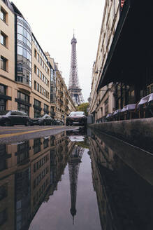 Frankreich, Ile-de-France, Paris, Eiffelturm spiegelt sich in Straßenpfütze - MMPF00666