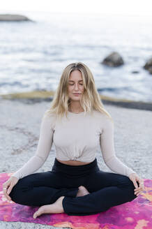 Frau im Lotussitz übt Yoga am Meer - MEF00158