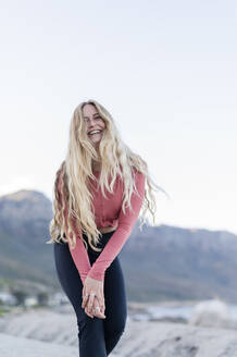 Glückliche junge Frau, die sich vor den Bergen amüsiert - MEF00162