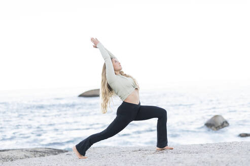 Junge Frau übt Yoga am Strand - MEF00169