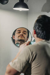 Reflection of man shaving with electric razor at bathroom - VSNF00370
