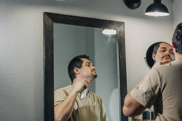 Man with electric razor shaving in bathroom - VSNF00371