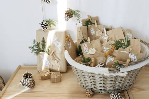 Decorated brown paper bags kept in basket for DIY advent calendar - SSYF00055