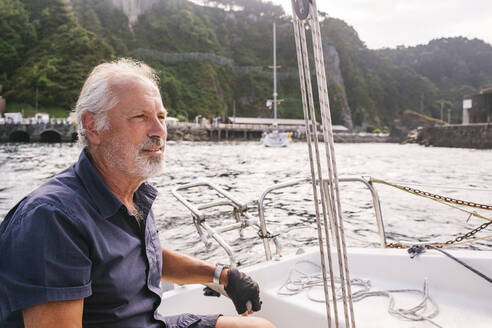 Nachdenklicher älterer Mann segelt Boot - MMPF00669