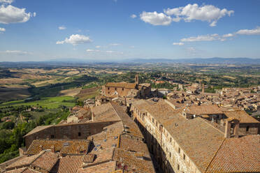 Italien, Toskana, Montepulciano, Dächer von alten Stadthäusern im Sommer mit ländlicher Landschaft im Hintergrund - MAMF02527