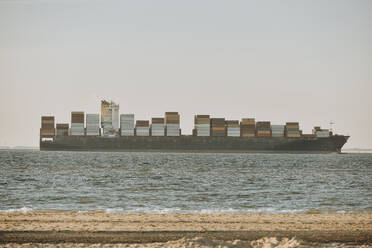 Niederlande, Zeeland, Groede, Containerschiff mit Strand im Vordergrund - FDF00343