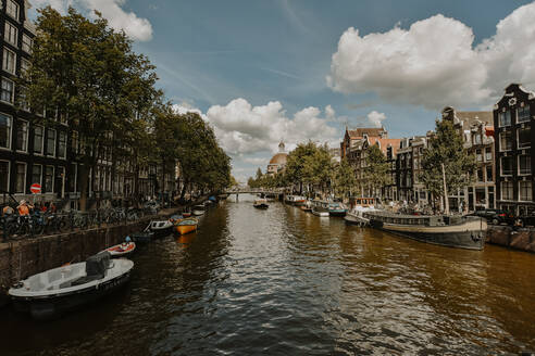 Niederlande, Nordholland, Amsterdam, Stadtkanal mit Reihen von vertäuten Booten auf jeder Seite - FDF00367