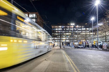 UK, England, Manchester, Langzeitbelichtung einer vorbeifahrenden Seilbahn bei Nacht - WPEF06927