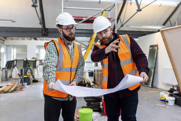 Gespräch eines Ingenieurs mit einem Kollegen auf der Baustelle - WPEF06931