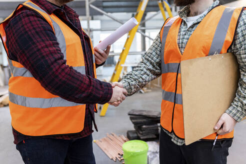 Engineers shaking hands with each other at construction site - WPEF06942