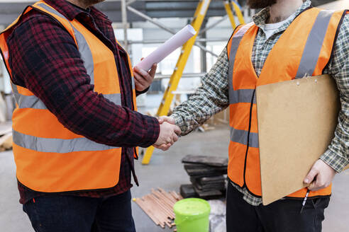 Ingenieure schütteln sich auf der Baustelle die Hände - WPEF06942