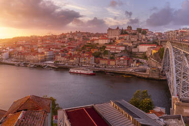 Blick auf die Brücke Dom Luis I. über den Fluss Douro mit bunten Gebäuden bei Sonnenuntergang, mit Blick auf den Stadtteil Ribeira, UNESCO-Weltkulturerbe, Porto, Norte, Portugal, Europa - RHPLF23409