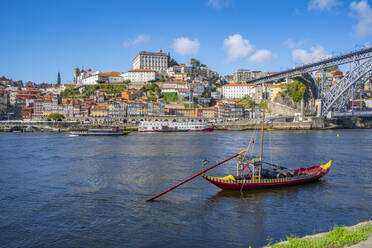 Blick auf die Brücke Dom Luis I. über den Fluss Douro und das Rabelo-Boot, ausgerichtet auf bunte Gebäude, UNESCO-Weltkulturerbe, Porto, Norte, Portugal, Europa - RHPLF23561