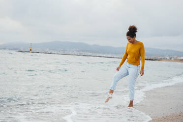 Junge Frau spielt am Strand - JOSEF15882