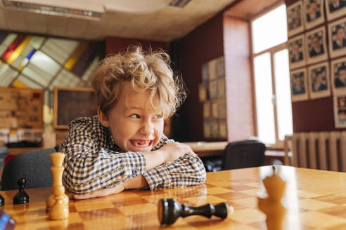 Junge sitzt am Tisch und spielt Schach im Country Club - OSF01340