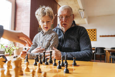 Grandfather and grandson playing chess at sports club - OSF01341