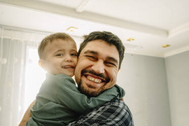 Happy father hugging son at home - ANAF00945