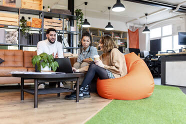 Businesswoman with coworkers sitting in office - WPEF06976