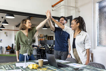 Happy business people doing high five in office - WPEF07051