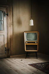 Alter Fernseher und Pendelleuchte in leerem Raum - MJRF00905