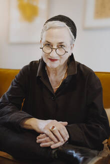 Smiling senior woman wearing eyeglasses at home - NGF00780