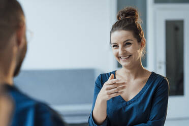 Happy businesswoman talking with colleague at home office - JOSEF15905