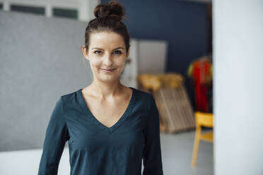 Smiling businesswoman standing at home office - JOSEF15920