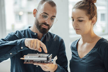 Businessman showing heating module to colleague at home office - JOSEF15944