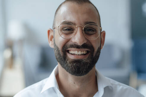 Happy businessman in beard wearing eyeglasses - JOSEF15982