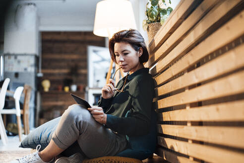 Junge Geschäftsfrau mit Tablet-PC an einem Heizkörper im Büro - JOSEF16051